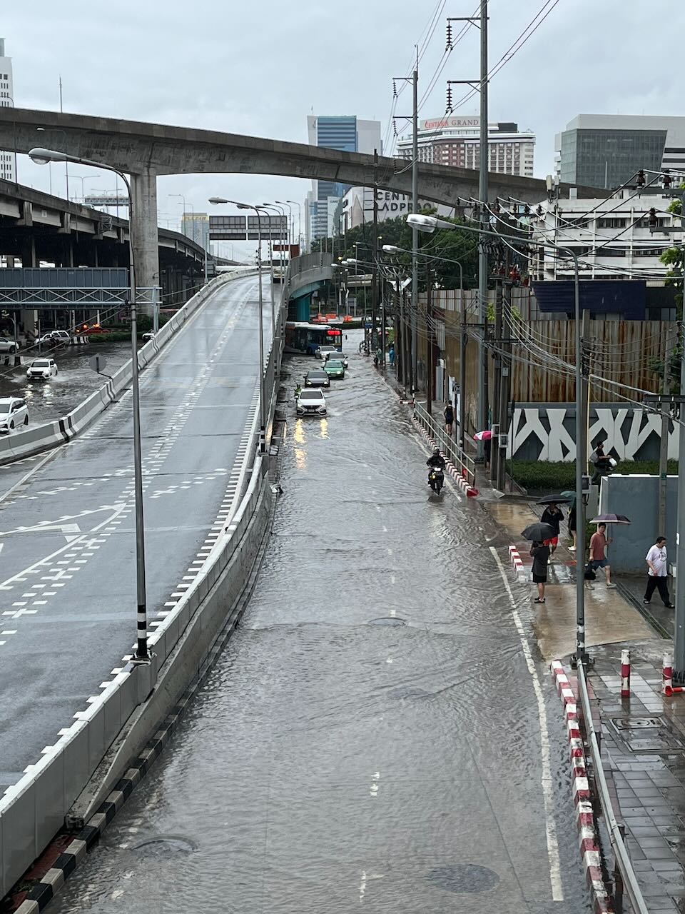 Cars driving through shallow floodwaters in Chatuhak district, Bangkok